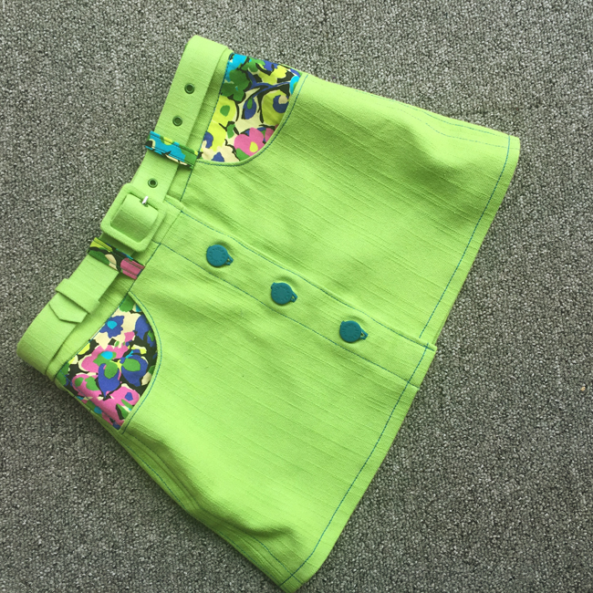 kid's lime green stretch denim mini skirt with matching belt and floral contrast pockets