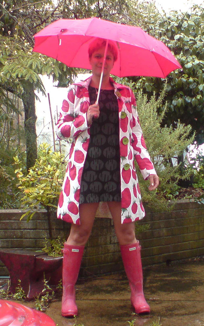 Bess standing in strawberry print Marimekko raincoat