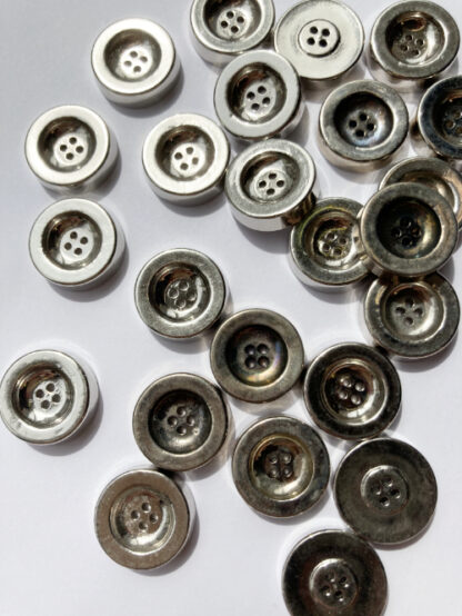 Silver vintage 1960's chunky 2 hole metal button. Due to age natural tarnishing of buttons cause colour variations