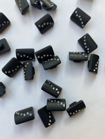 Black oblong plastic button on shank with diamante