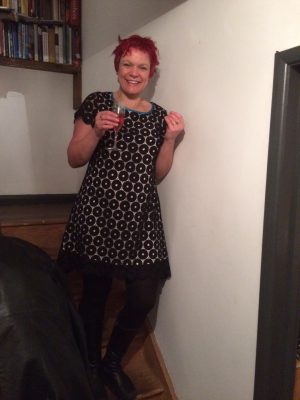 Bess wearing black circles lace dress holding a glass of bubbly