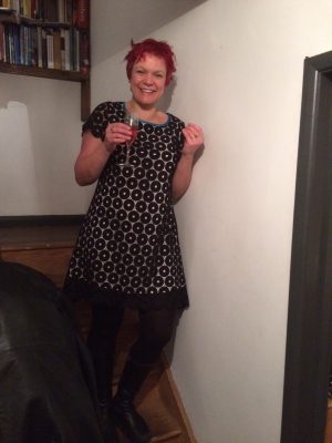 Bess wearing black circles lace dress holding a glass of bubbly