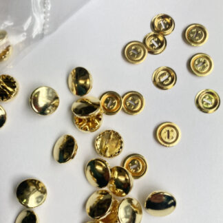 Brass metal (nickel free) 2 part cover button (sold individually without tool). We can provide a template to use to cut your circle of fabric. Cover buttons are great for vintage garments and where you want the buttons to match perfectly with your fabric. We recommend you interface very fine fabrics before using so the shine from the metal does not show through. You do not need the tool to construct these buttons but if you are doing many you may find it useful. When deciding on the size of button remember the thickness of the material will add to the size - so, E.G. an 11mm button covered in a brocade could measure 13mm once covered
