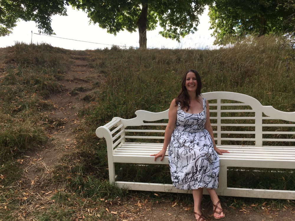 catharine sitting on wooden bench wearing cotton voile monochrome scribble print dress