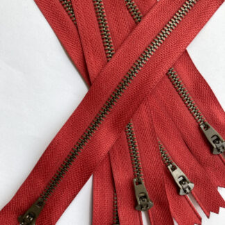 Red tape with antique brass metal teeth jeans zip