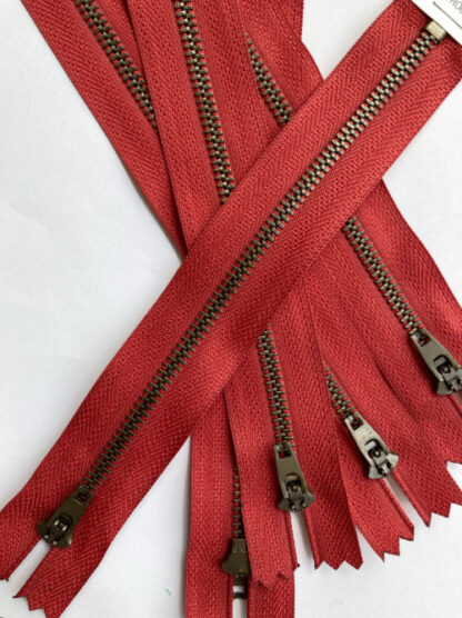 Red tape with antique brass metal teeth jeans zip