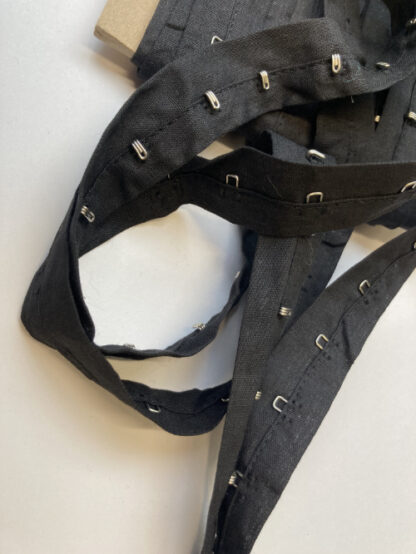 Black hook and eye fasteners on 100% cotton tape, hooks every 25mm