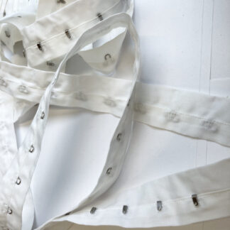 White hook and eye fasteners on 100% cotton tape, hooks every 25mm