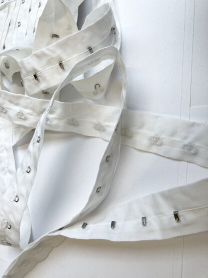 White hook and eye fasteners on 100% cotton tape, hooks every 25mm