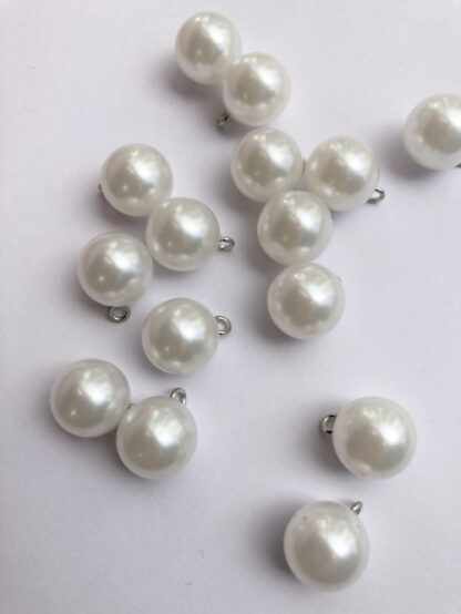 White pearl effect round plastic button on shank