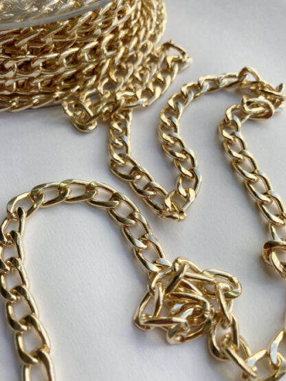 Gold coloured metal chain 3 links per inch. A weighty chain (steel alloy) that's perfect for weighing down cardigan jacket hems and other decorative trimming uses