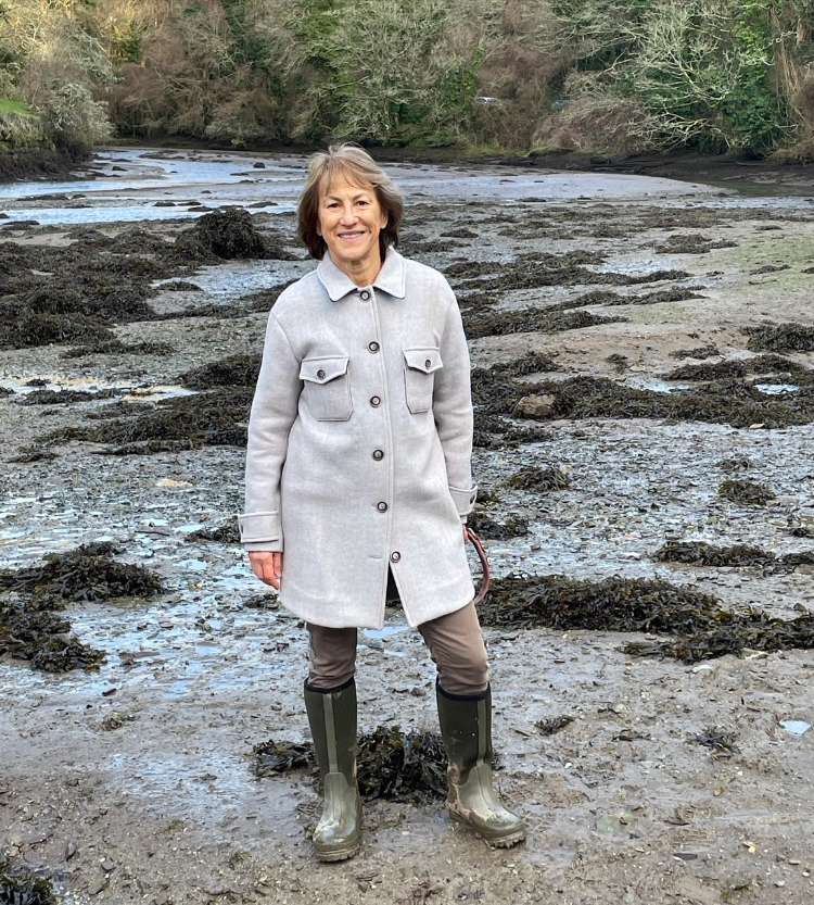 lis standing on the sea shore wearing a buttoned up light grey reversible coating Ingrid coat