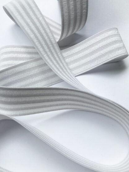 White 60% Polyester 40% Rubber sport elastic -great fold resistant elastic for enclosed waistbands and can be sewn through in channels if desired. 