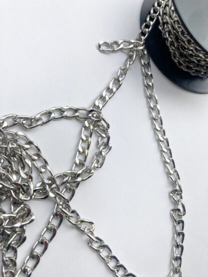 Silver coloured metal chain 3 links per inch. A weighty chain (steel alloy) that's perfect for weighing down cardigan jacket hems and other decorative trimming uses