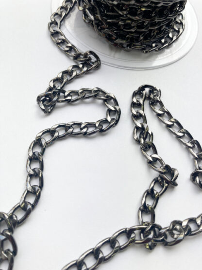 Gunmetal coloured metal chain 3 links per inch. A weighty chain (steel alloy) that's perfect for weighing down cardigan jacket hems and other decorative trimming uses