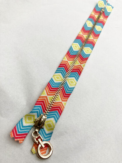 Red, orange, yellow and turquoise multicolour aztec printed fancy metal 8” zip